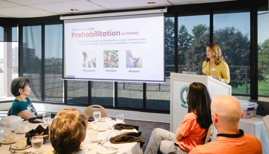 Dr. Jordan Leitch (at the podium) gives a presentation during a Women’s Giving Circle luncheon.